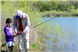 Adult helps child with fishing rod