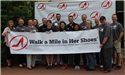 Walk a Mile in Her Shoes Team with Comm. Sivarajah and Comm. Schulte holding the banner