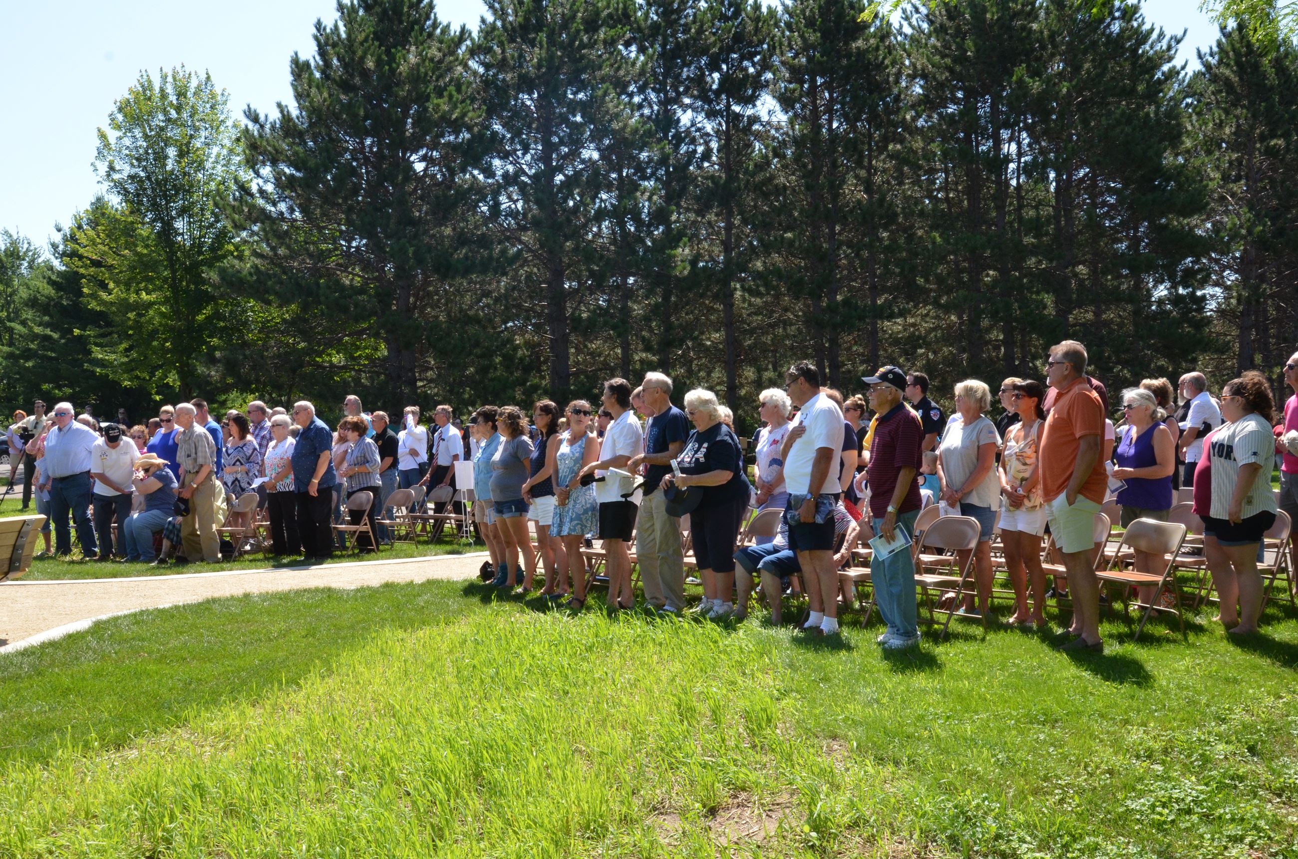 The crowd stands for the raising of the flag