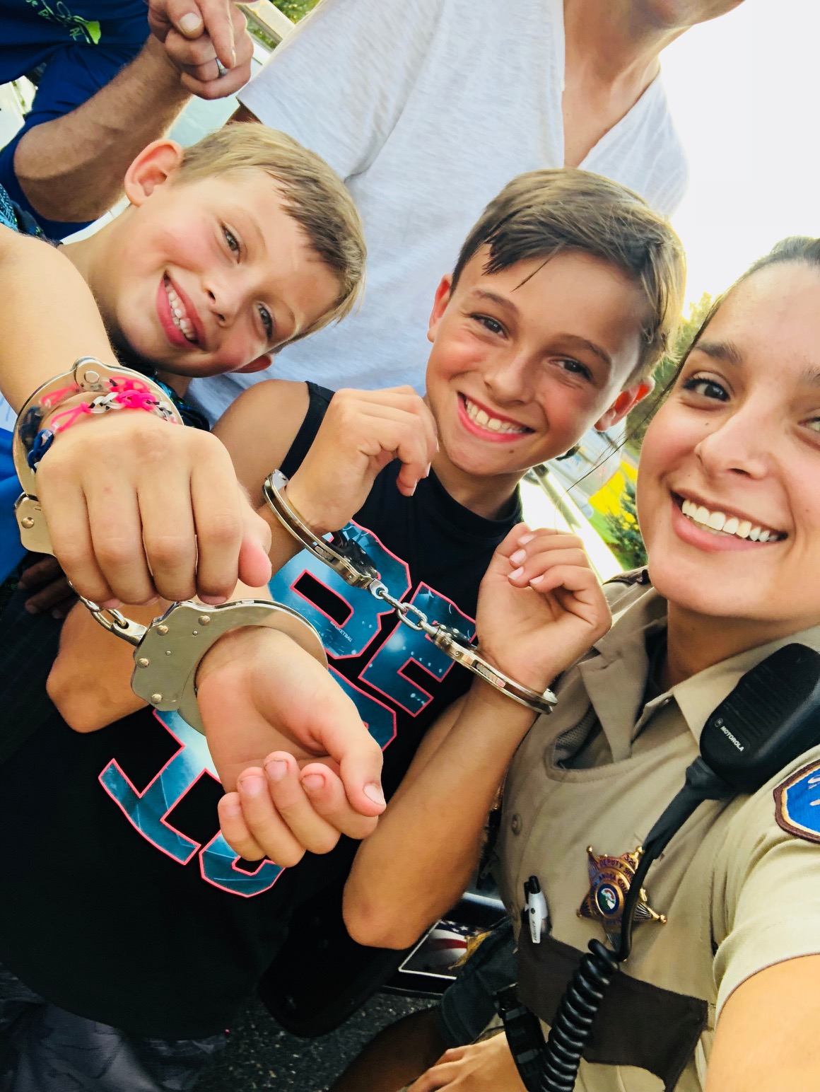 Deputy posing with kids at a Night to Unite party